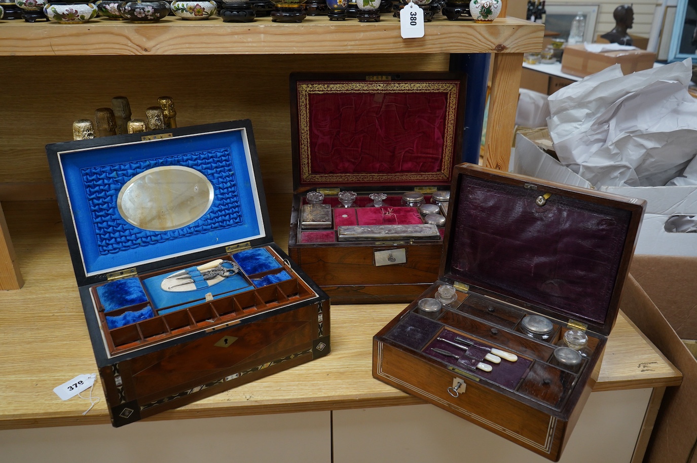 Three 19th century vanity and sewing boxes with fitted interiors to include a mother of pearl inlaid example with glass bottles, jars and mirror, largest 35cm wide. Condition - fair, some losses